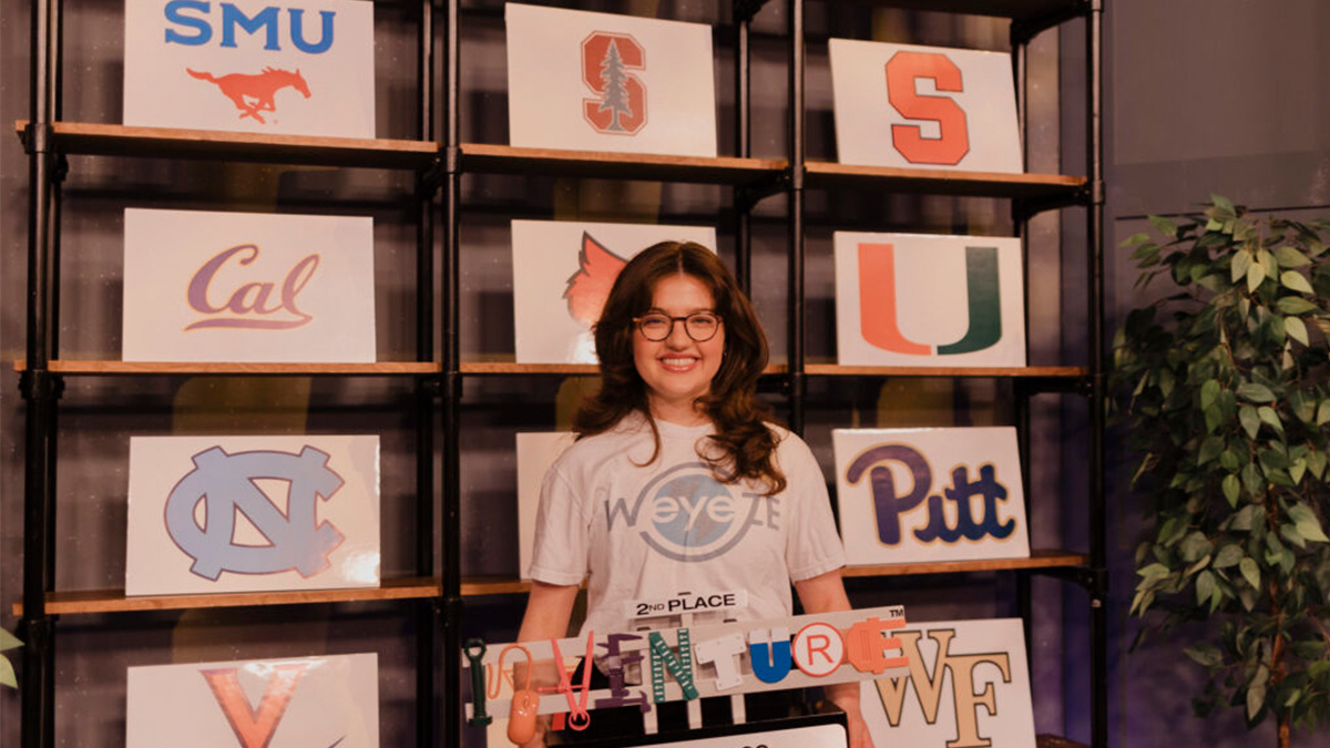 Sasha Surkin wearing a UNC shirt stands in front of some university signs.